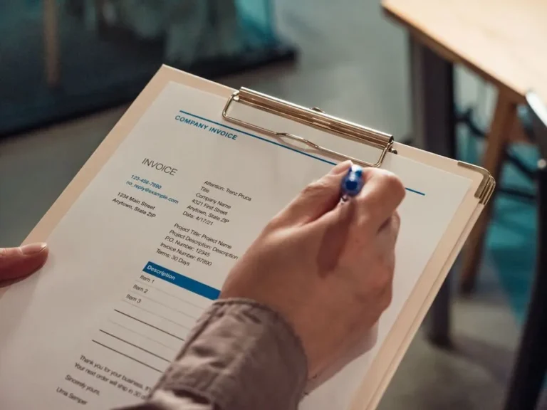 Finance staff reviewing invoice approvals on a clipboard as part of a Saudi SME workflow